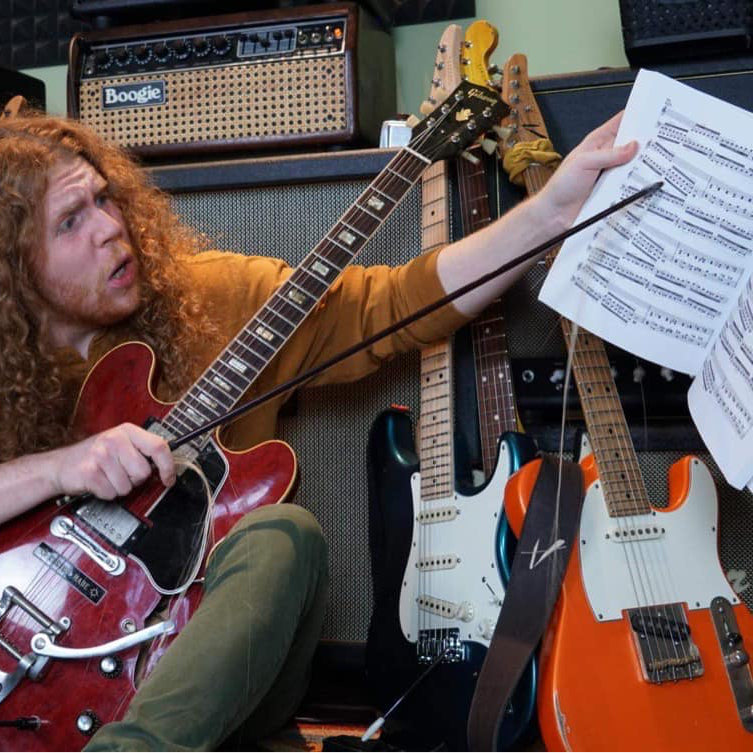 Sean Ashe working through written music during a guitar lesson